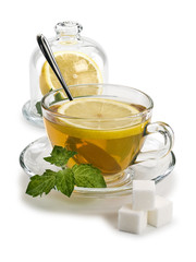 Green tea, lemon, mint and sugar in glassware