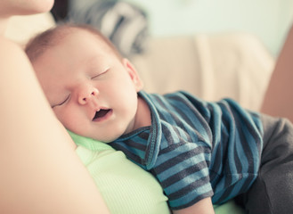 Fototapeta premium Cute baby boy sleeping in mothers arms. 