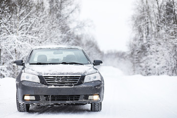 The car stands on a snow-covered road