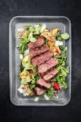 Fototapeten Modern Style Italian tagliata di manzo with lamb salad dry aged sliced roast beef as top view in a skillet © HLPhoto