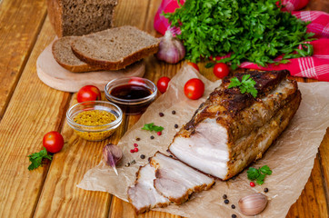 Roast pork belly in mustard honey glaze on a dark wooden background. Rustic style.