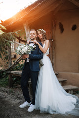 Fototapeta premium Bride and groom at wedding Day walking Outdoors on summer nature. Bridal couple, Happy Newlywed woman and man embracing in green park. Loving wedding couple outdoor. Bride and groom