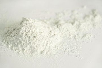 Kitchen still life with scattered flour on the white table. Closeup
