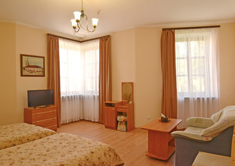An interior of the hotel room with two windows. Modern classics