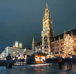 Blurred moved people and sales booth at the christmas market on Marienplatz against Town Hall Neues...