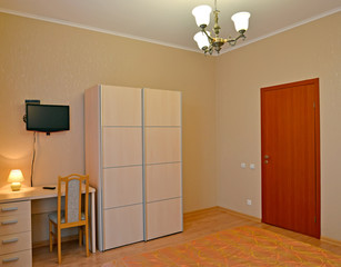 Fragment of an interior of the hotel room of economy class with a desk