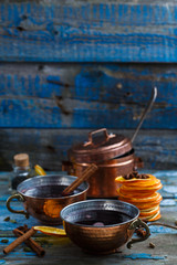Mulled wine in copper cups with spices and citrus fruit, copy space
