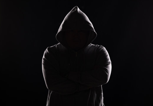 studio portrait of a guy in a hood on a black background