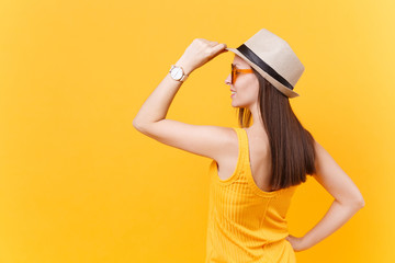Back rear portrait view of young woman in straw summer hat, orange glasses put hands on head, copy space isolated on yellow background. People sincere emotions, lifestyle concept. Advertising area.