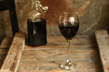 glass of red wine and a bottle on the table (alcohol). Top view. food background copy space