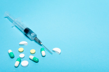syringe, treatment, vitamins multicolored on a blue background, antibiotics, pills