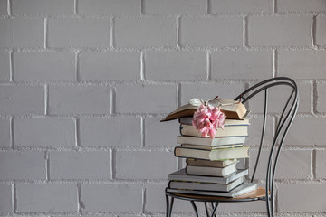 books on a seat in front of a white brick wall background