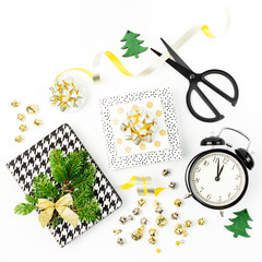 Christmas decorations with alarm clock and gifts in gold colors on white background with empty copy space for text. Holiday and celebration. Flat lay, top view