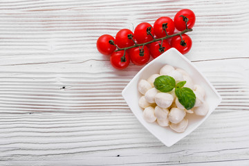 Mozzarella tomatoes and basil on a wooden rustic background