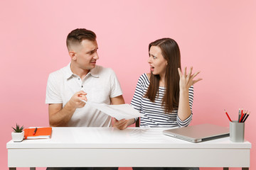 Two young tired business woman man colleagues sit work at white desk with contemporary laptop...