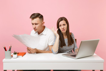 Two young angry business woman man colleagues sit work at white desk with contemporary laptop...