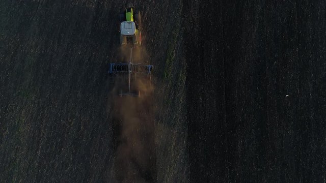 Aerial : the tractor goes to the field. Agriculture, a tractor plows the land.