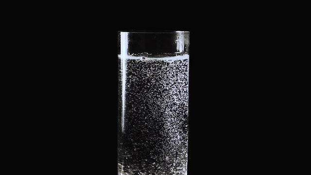 Carbonated bubbles dancing above a glass