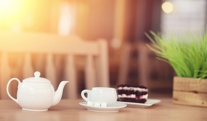 Kettle with a drink and dessert in a street cafe. Tea in the ket
