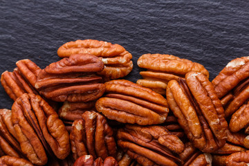 delicious pecan nuts on a dark stone background