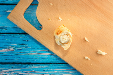 Bread, bun, crumbs scattered on a wooden board