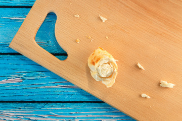 Bread, bun, crumbs scattered on a wooden board