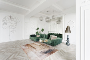 Morning in luxurious light interior in the Baroque style. Bright and clean interior design of a luxury living room with parquet wood floors, fireplace, sofa and houseplant. Stucco on walls