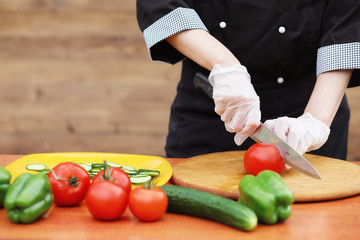 The cook cuts fresh farm vegetables