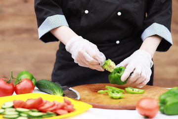 The cook cuts fresh farm vegetables
