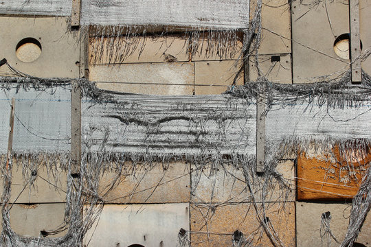 Old tattered wall insulation, torn nylon burlap sacks and wooden planks as background