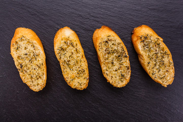 fragrant garlic bread on a dark stone plate