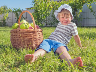 He healthy food concept. Cute boy sitting near apples. Taking a rest after hard work.