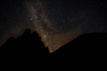 Saturn appear at the base of Milky Way with dolomite mountain background, South Tyrol, Italy
