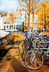 Row of bicycles standing next to canal in Amsterdam at fall, Netherlands
