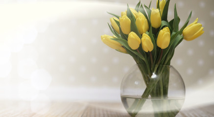  bouquet of yellow tulips in a vase on the floor