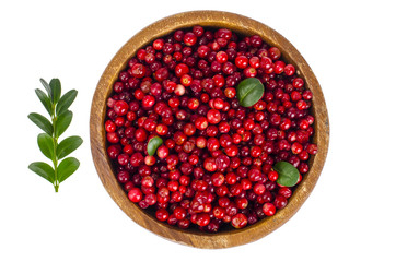 Wooden plate with red bilberry berries on white background