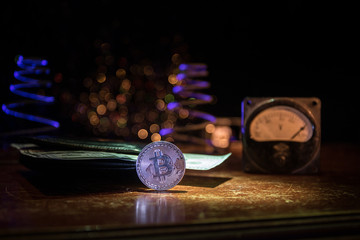 Energy for mining cryptocurrency. The energy meter with bitcoin and money on dark toned foggy...
