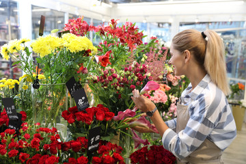 Beautiful female florist working in flower shop