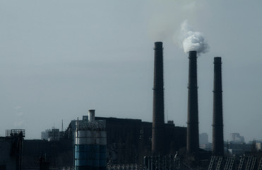 Smoke stack in working plant emitting smog and air pollution 