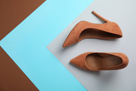 Pair of beautiful shoes and space for text on color background, top view