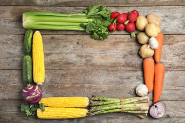 Flat lay composition with fresh vegetables and space for text on wooden background