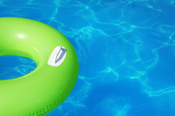 Inflatable ring floating in swimming pool on sunny day. Space for text