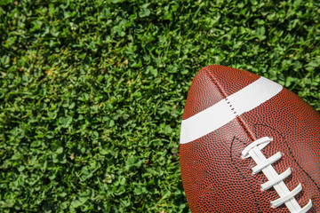 Obraz premium Ball for American football on fresh green field grass, top view. Space for text