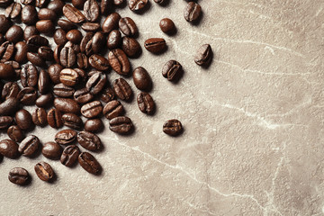 Roasted coffee beans on grey background with space for text, top view