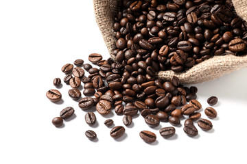 Overturned bag with roasted coffee beans on white background, closeup