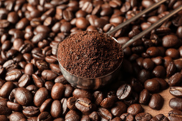 Spoon with coffee grounds and roasted beans, closeup