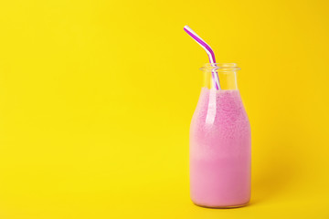 Bottle of tasty milk shake and space for text on color background