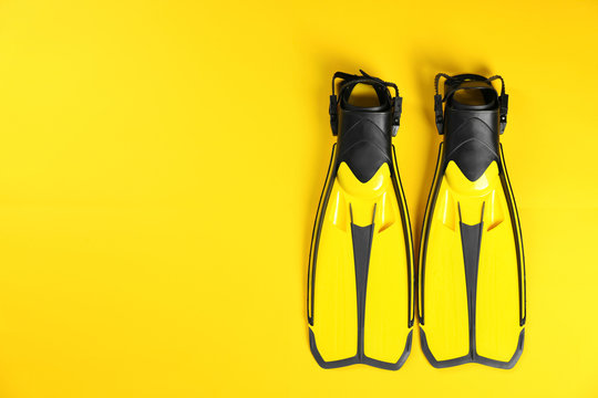 Swimming flippers on color background, top view. Space for text