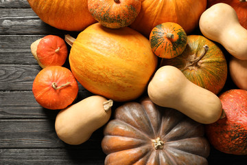 Flat lay composition with different pumpkins on wooden background. Autumn holidays