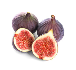 Whole and cut purple figs on white background